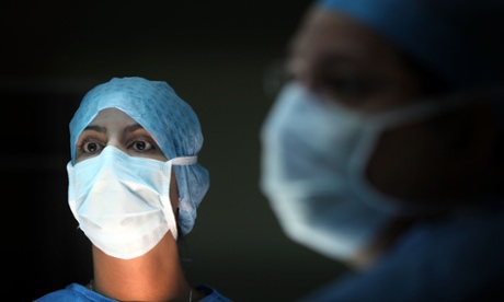 A surgeon and his theatre team perform an operation.