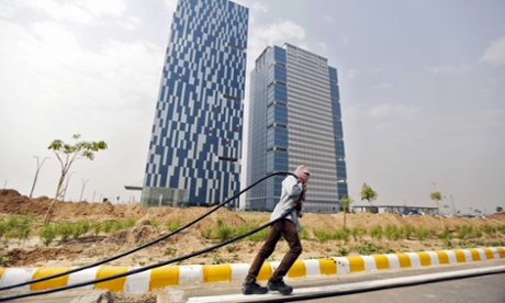 A labourer pulls a cable in front of office buildings in Gujarat International Finance Tec-City (Gift City).