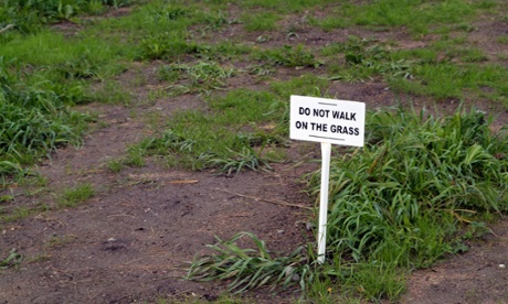 A worn lawn with a sign saying 