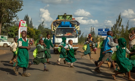 Children on their daily journey to school across the Thika Road in Nairobi, Kenya. 