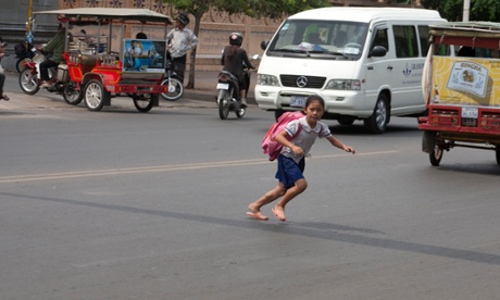 A junior school girl crossing to classes in Phnom Penh, Cambodia