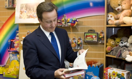 David Cameron leafs through a book at a Helen & Douglas House charity shop.
