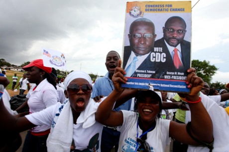 A supporter holds a poster with images of presidential candidate Winston Tubman and his running-mate George Weah of the Congress for Democratic Change in Monrovia before the 2011 presidential elections.