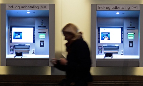 A woman passes cash-machines in downtown Copenhagen.