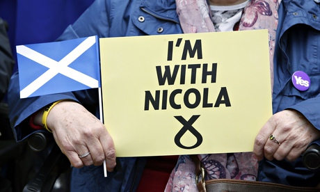 An SNP supporter holds a sign