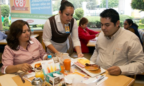 A waitress serves breakfast to customers