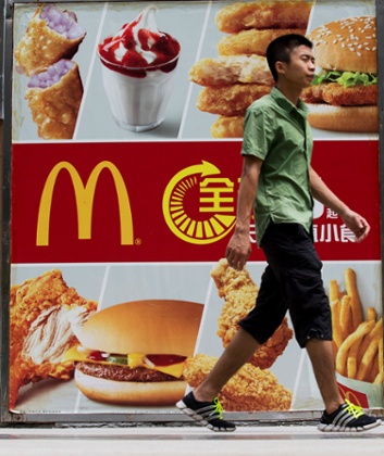 A pedestrian walks past an advertisement for McDonald's Corp. in the Futian district of Shenzhen, China.