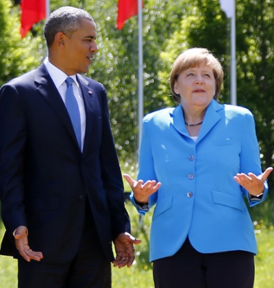 German Chancellor Angela Merkel, right, speaks with U.S. President Barack Obama during a group photo at the G-7 summit at Schloss Elmau hotel near Garmisch-Partenkirchen, southern Germany, Sunday, June 7, 2015. The two-day summit addressed such issues as climate change, poverty and the situation in Ukraine.