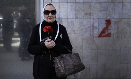 A woman in Cairo holds holds a red flower in protest at the death of the Egyptian poet Shaimaa al-Sabbagh, who was killed when police fired at unarmed demonstrators in January.