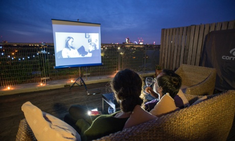 DO SOMETHINGRhik Samadder and his girlfriend, Alice, are showing us how to make our own outdoor cinema. The place is warm and looking picturesque with fairy lights, candles in jars and a beautiful sunset on the background. Photograph: Alecsandra Raluca Dragoi for The Guardian