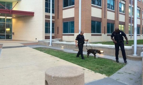 Police officers use a dog while searching for explosives