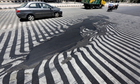 Road markings appear distorted as the asphalt starts to melt due to the high temperature in New Delhi, India, 27 May 2015.