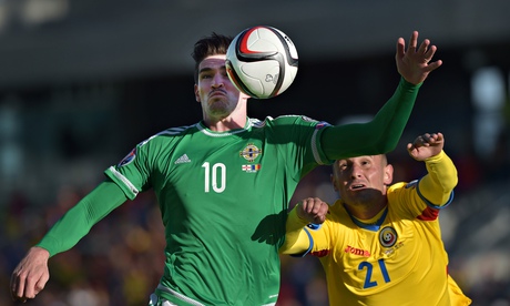 Kyle Lafferty of Northern Ireland and Dragos Grigore of Romania battle for the ball 
