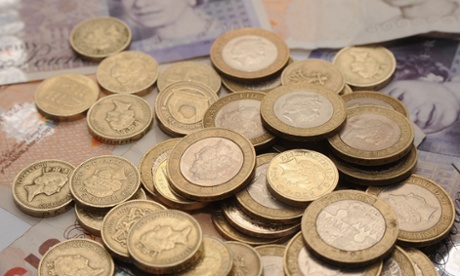 A selection of one pound coins, two pound coins and bank notes.