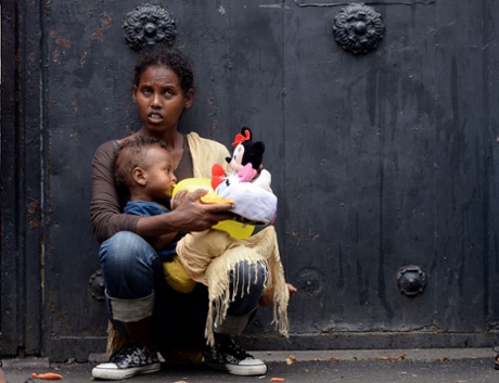 A mother holds her child with toys brought by aid workers outside Baobab migration centre next to the Tiburtina train station in Rome.