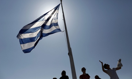 Tourists under a Greek national flag on the Acropolis in Athens while Alexis Tsipras leads talks with EU officials.