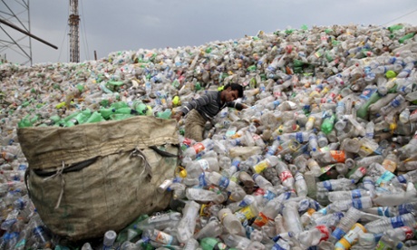 A man pulls a sack filled with empty bottles at a plastic junkyard in Chandigarh, India.