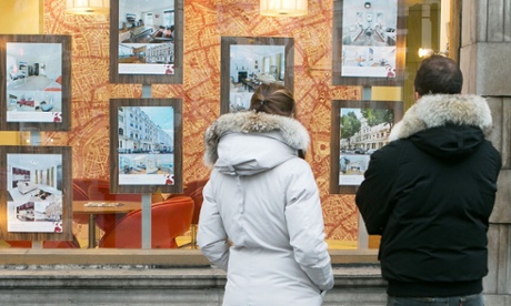 Young people looking in an estate agent's window