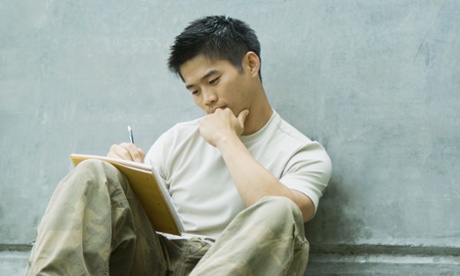 Young man sitting on grass.