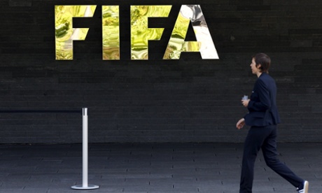 Staff walks past a logo of soccer's international governing body FIFA at their headquarters in Zurich, Switzerland, 27 May 2015.