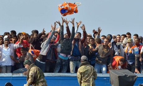 Royal Marines from HMS Bulwark help rescue migrants stranded on a boat, thirty miles off the Libyan coast, on 7 June.