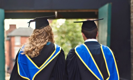 CX0AXT Two graduates walking away together at their graduation ceremony