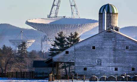 big telescope towering over wooden barn