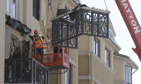 Workers remove part of a balcony that collapsed.