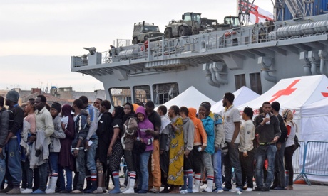 Migrants queue at the port of Catania