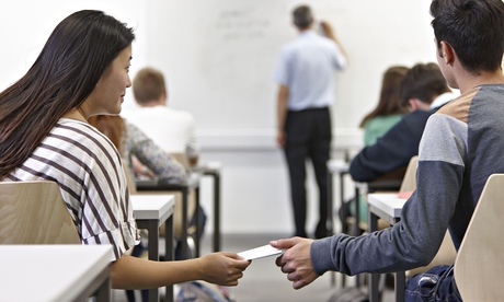 Teenagers pass notes in the classroom