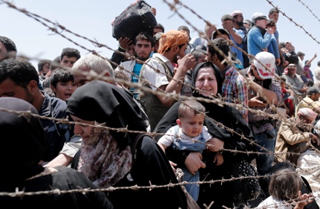 A picture taken from the Turkish side of the border between Turkey and Syria shows Syrian refugees waiting on the Syrian side of the border crossing near Akcakale, Sanliurfa province, south-eastern Turkey, 10 June 2015.