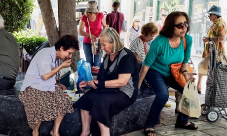 Pensioners eat a meal on streets of Athens.