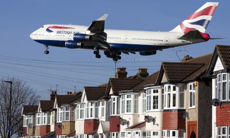 A British Airways 747 aircraft flies over roof tops as it comes into lane at Heathrow airport.