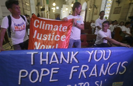 Environmental activists display a banner as they prepare to listen to speeches inside a Roman Catholic church to coincide with Pope Francis' encyclical on climate change Thursday, June 18, 2015 in Manila, Philippines. In a high-level, 190-page document released Thursday, Francis  describes ongoing human damage to nature as 