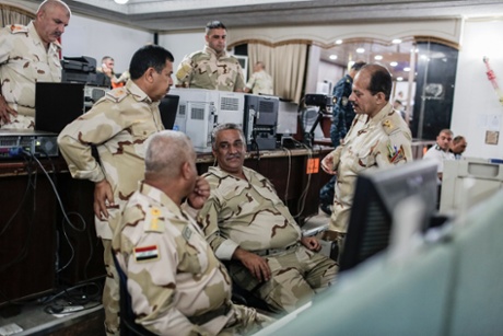 Officers talk in the Baghdad Operations Command control room 