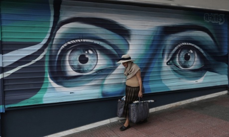 'Austerity has clearly been a disaster'. An elderly shopper passes a closed shop in central Athens.