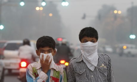 Children cover their faces to try to protect themselves from air pollution in the Indian capital.