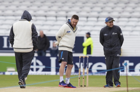Brendon McCullum, centre, examines the wicket before play.
