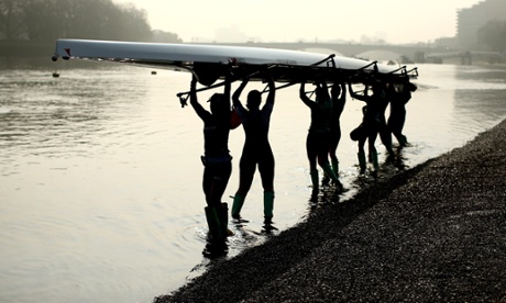A women's rowing team lifts their boat