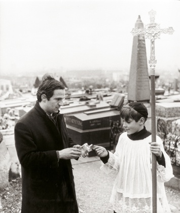 Director Francois Truffaut gives a cigarette to an extra dressed as a choirboy during the filming of Jules et Jim, Rouen, 1961.