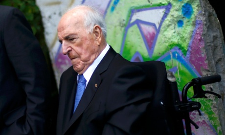 Helmut Kohl sitting in front of part of the Berlin wall in his garden. He has used a wheelchair for several years.