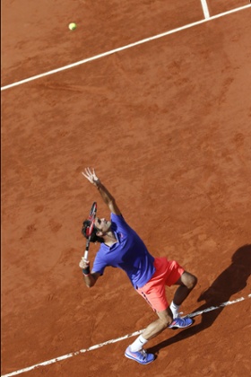 Roger Federer serves.