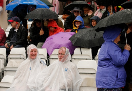 Spectators take shelter from the rain.