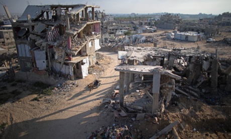 A donkey and cart move through the dust and rubble of bombed homes in Gaza City earlier this month. Many buildings are still waiting to be demolished or rebuilt nearly a year on from the 2014 conflict