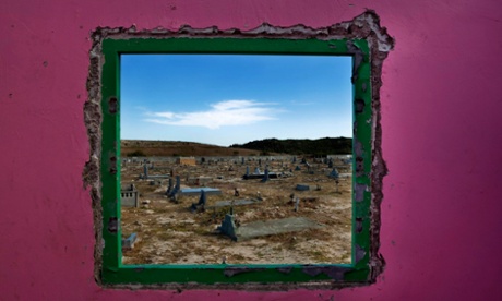 Graves in Khayelitsha seen through the window of an abandoned cemetery caretaker’s hut.