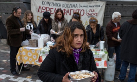 A woman receives a portion of food at a soup kitchen in Athens.
