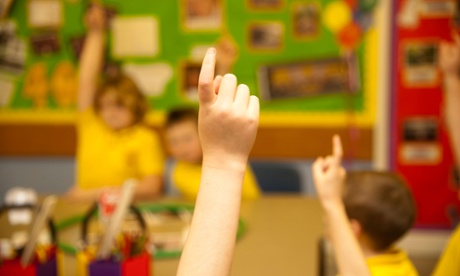 Children raising hands in class