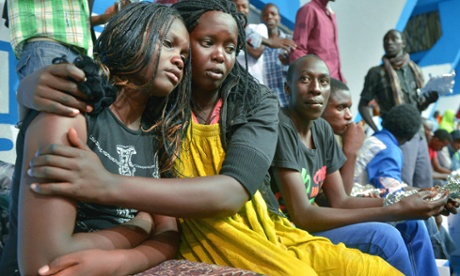 A survivor of an attack by islamist gunmen claimed by al-Shabab on a university campus in Garissa, northern Kenya is comforted by a colleague after arriving in Nairobi on April 4, 2015.