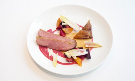 Slices of duck breast and boned-out confit leg on a round plate