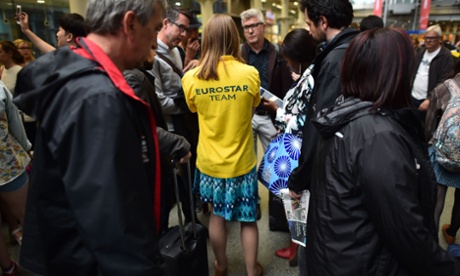 A member if the Eurostar Team talk to passengers queuing at the Eurostar terminal at St Pancras station